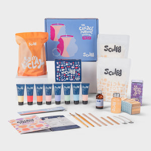 Kit per candele per due in una scatola azzurra con colori pastello e timbri con lettere