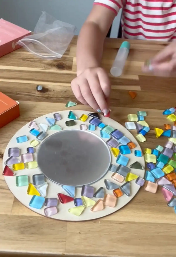A kid working on mirror mosaic with Sculpd kids mosaic kit