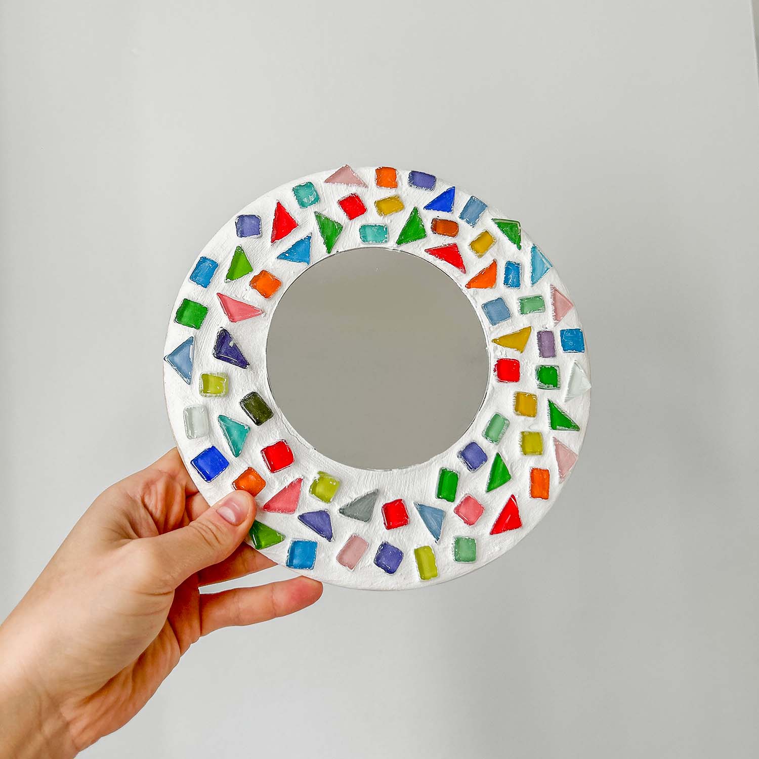 A round mirror with colourful mosaic tiles with Sculpd kids mosaic kit
