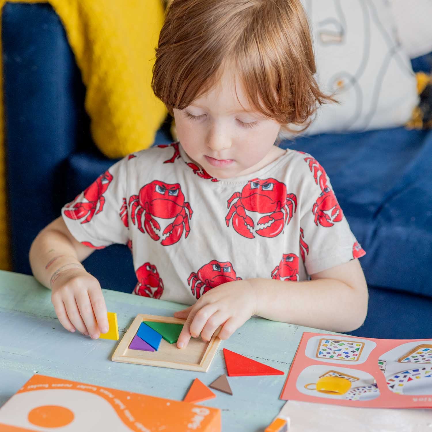 A kid enjoing his tangram tile from Sculpd kids mosaic kit