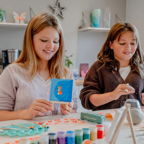 Two kids engaged in an artful hobby with Sculpd canvas painting kit