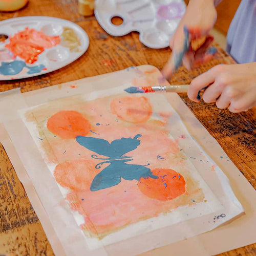 A child painting a cute butterfly with Sculpd kids canvas kit